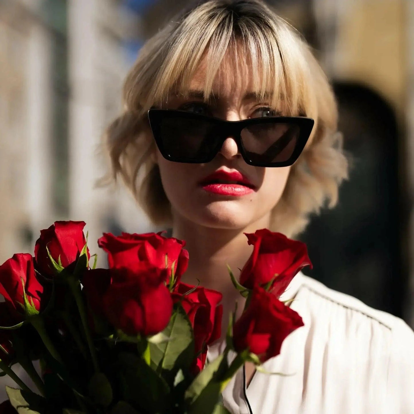 Buquê de Rosas Vermelhas e Chocolates Arcádia - modelo com os óculos pretos e as rosas vermelhas | QRoses